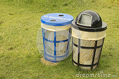 Trash bins in grassy park Stock Photo