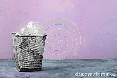 A trash can for paper. Beautiful background with place for text. A full trash can for crumpled paper sheets. Stock Photo