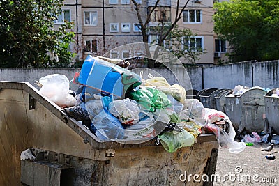 Trash in overloaded garbage bins in courtyard of residential district Editorial Stock Photo