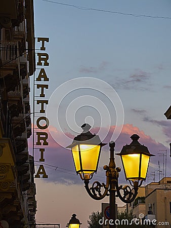 Trattoria signboard in at nightfall. Stock Photo