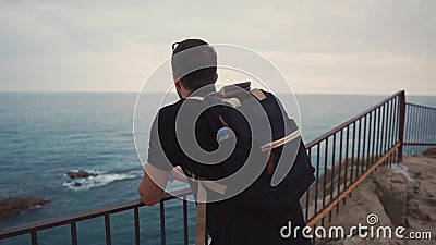 Trauriger erwachsener Mann passt allein auf Meerblick auf, wenn er Zeit vom Felsen glättet stock video footage Trauriger erwachsener Mann passt allein auf Meerblick auf, wenn er Zeit vom Felsen glättet stock video footage