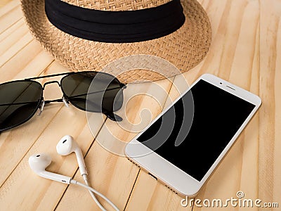 Travel accessories concept. Smartphone, earbuds, sunglasses, hat Stock Photo