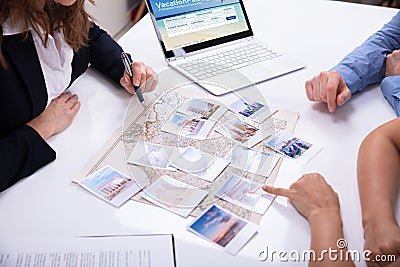 Travel Agent Giving Information To A Young Couple Stock Photo