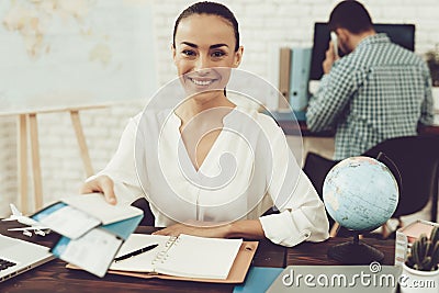 Travel Agent Holding Tickets in Travel Agency. Stock Photo