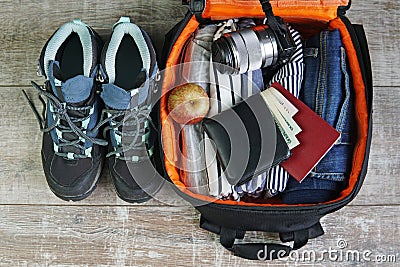 travel backpack with jeans shirt wallet passport shoes and camera top view Stock Photo