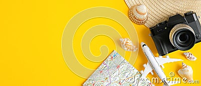 Travel banner design template with airplane model, map, vintage camera, beach hat and seashells on yellow background. Top view Stock Photo
