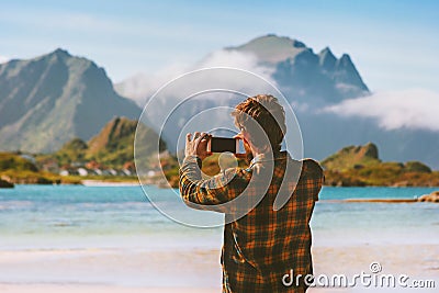 Travel blogger man taking photo by smartphone in Norway influencer outdoor Stock Photo
