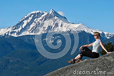 Travel Canada. Woman on mountain cliff against snow capped peak. Stock Photo