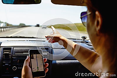 Travel in car concept, girl shows smartphone in her hand with opened gps navigation app Stock Photo