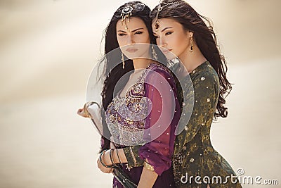 Travel concept. Two gordeous women sisters traveling in desert. Arabian girls. Stock Photo