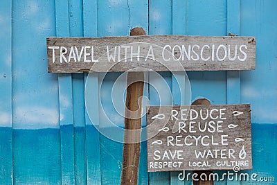 Travel with a conscious wooden sign on blue wooden background Stock Photo