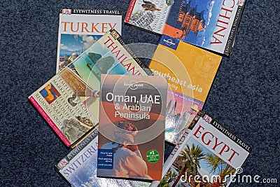 Travel country books scattered on the floor searching for next global vacation. Decision time Editorial Stock Photo