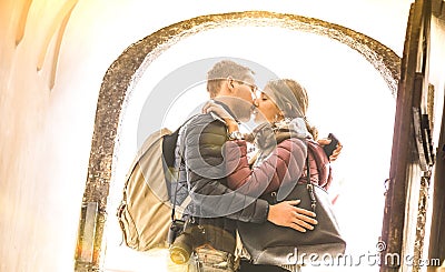 Travel couple in love kissing outdoors at city tour excursion - Young happy tourists enjoying romantic moment at sunset Stock Photo