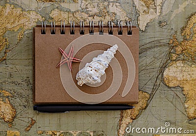 Travel flat lay with notepad and seashells placed on map Stock Photo