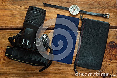 Travel flatlay on brown wooden background with camera, international passports, wallet and compass Stock Photo