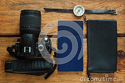 Travel flatlay on brown wooden background with camera, international passports, wallet and compass Stock Photo