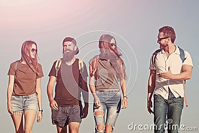 Travel friends on blue sky, travelling. Yong group of people hiking. Stock Photo