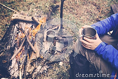 Travel girl drinking from a mug. Camping hiking lifestyle. Stock Photo