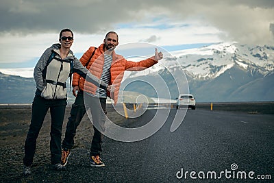 Travel hitchhiker couple on a road Stock Photo