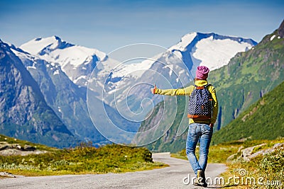 Travel hitchhiker woman walking on road during holiday travel Stock Photo