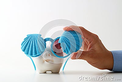 Travel insurance concept.business insurance agent hand in gesture of protection of piggy bank with shell sunglasses on white back Stock Photo