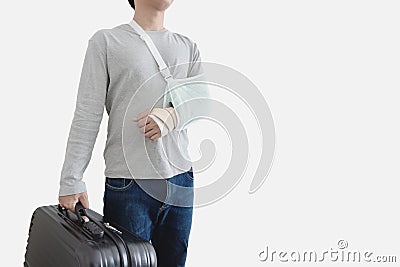 Travel insurance concepts. Young man with hand injured wearing splint, broken arm, holding black baggage, Stock Photo