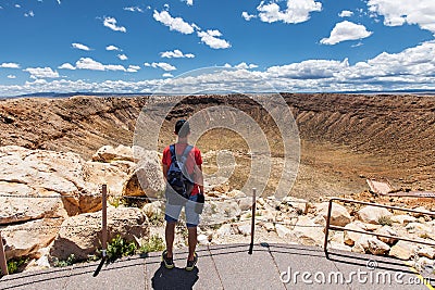 Travel in Meteor Crater, man hiker with backpack enjoying view, Winslow, Arizona, USA Stock Photo