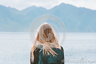 Travel in Norway globetrotter woman with backpack looking at mountains view Stock Photo