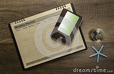 Travel Planner sheet with passport and credit card on wooden table top with star fish and world glass marble Stock Photo
