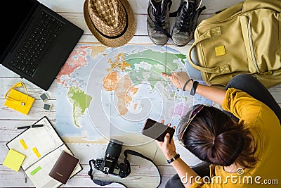Travel planning concept with map. Overhead view of equipment for travelers. Travel concept background, Young woman pointing to the Stock Photo