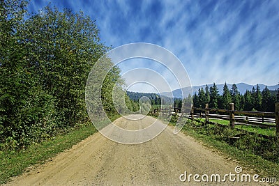 Travel road on the field with green grass and blue sky with clouds on the farm in beautiful summer sunny day. Clean, idyllic, land Stock Photo