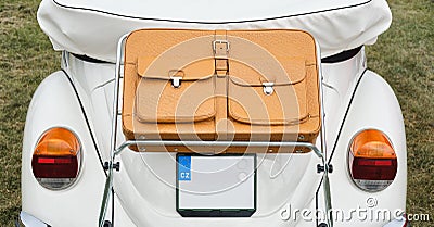 Closeup of a brown leather suitcase mounted on the back of a vintage cabriolet car. Editorial Stock Photo