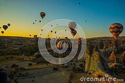 Travel to Goreme, Cappadocia, Turkey. The sunrise in the mountains with a lot of air hot balloons in the sky Editorial Stock Photo