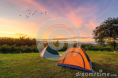 Travel to spread the tent in a wide open space in the evening. The golden sky mountain views on the Nakhasat Sabai In Chiang Mai Stock Photo