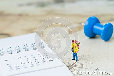 Travel, tourism, vacation or wanderlust life concept, miniature young man backpacker standing on vintage world map with compass, Stock Photo