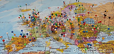 Travel Visitors Marking Locations on a colorful World map with push pins. Stock Photo