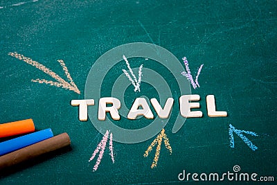 TRAVEL. White letters of the wooden alphabet. Colored pieces of chalk on a green chalk board Stock Photo