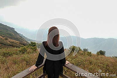 Traveler asia woman look out at viewpoint on the woooden fence on Mountain Kew Mae Pan,Doi Inthanon Chiang Mai Editorial Stock Photo