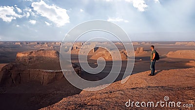 Traveler on the background of rocky formations in the Dasht e Lut desert. Nature of Iran. Persia. Stock Photo