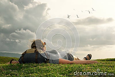 Traveler with backpack looking at sky and clouds over mountains Stock Photo
