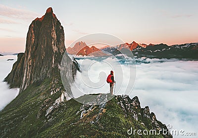 Traveler on cliff over clouds exploring sunset Segla mountain Stock Photo