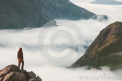 Traveler on cliff overlooking mountain clouds alone Stock Photo