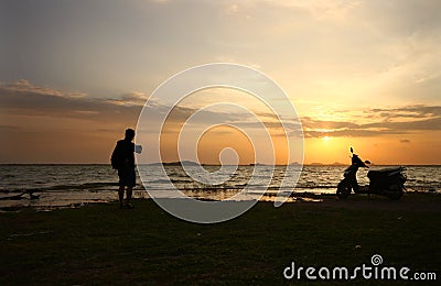 Traveler enjoying sunset with his bike Stock Photo