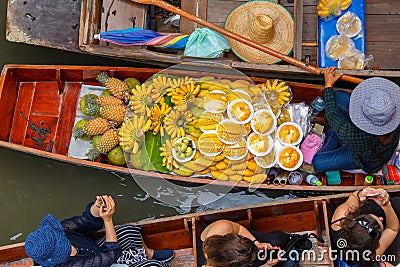 Traveler enjoying and take a photo with smartphone on long trail boat at Damnoen Saduak floating market Editorial Stock Photo