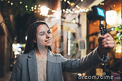 Traveler female blogger shooting video for vlog social media with digital camera. Smiling woman vlogger taking photo selfie Stock Photo