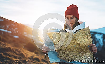 Traveler girl hold in hans map and look sun flare, people planning trip, hipster tourist on background nature, enjoy journey land Stock Photo
