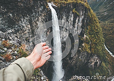 Traveler hand showing waterfall travel in Norway Stock Photo