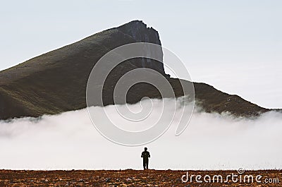Traveler hiking alone in cloudy mountains travel adventure Stock Photo