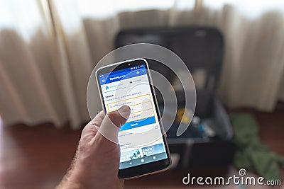 Traveler looking up booking.com on a phone july 25 2019 Editorial Stock Photo