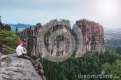 Traveler man on rocky edge with sharp rocks on background Stock Photo